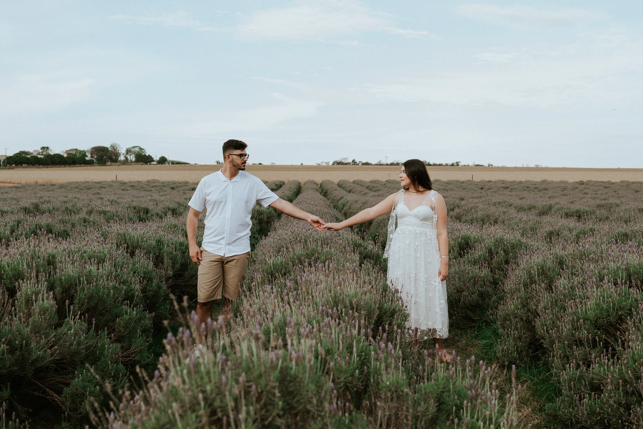 Casal caminhando em um campo florido